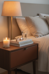Leather bedside cabinet styled with candle, books and warm lamp in a cozy bedroom